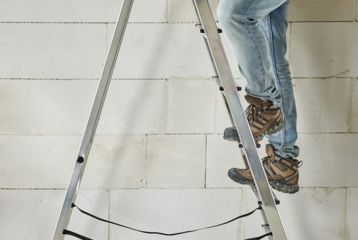 Worker is standing on the ladder